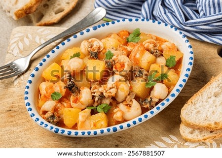 Close up of Cuttlefish stew with potatoes. Bread. Spanish meal.