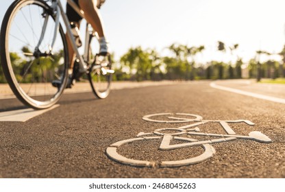 Close up cycling logo image on road with athletic women cyclist legs riding Mountain Bike in background at the morning. - Powered by Shutterstock