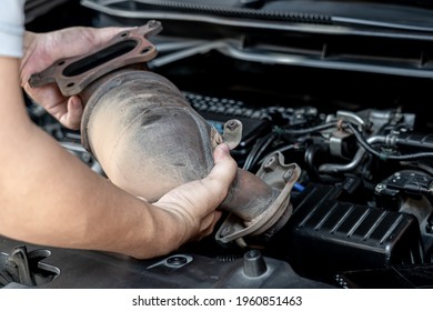 Close up Damaged Catalytic car in hand man remove from engine gasoline car dust clogged condition on filter in service concept - Shutterstock ID 1960851463
