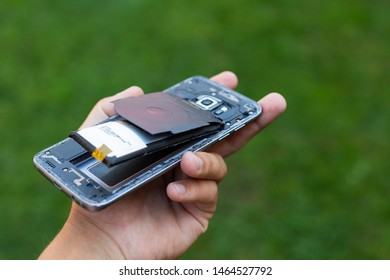 Close up of a damaged smartphone with expanded lithium ion battery