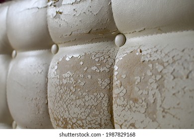 Close Up Of Damaged White Leather Soft Tufted Furniture Or Bed Panel Upholstery. Bad Quality Leather 