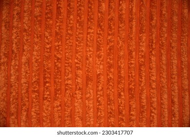 close up of damp orange textured fabric with lines between the low pile and high pile parts of the fabric. soft comfy warm vibrant, happy, cozy. background with copy space