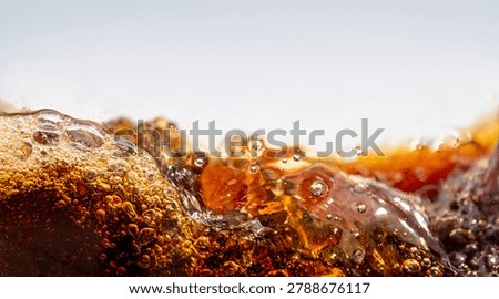 Close up of dark cola splashing with bubbles and droplet on white background. Dynamic liquid wave texture, refreshing soda macro shot for commercial use, beverage advertising abstract concept