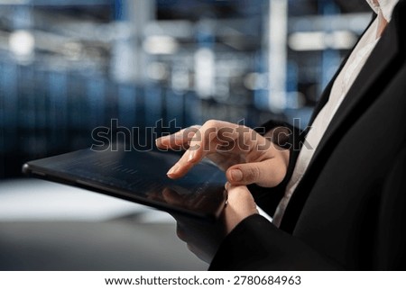 Close up of data center computer scientist typing on tablet, configuring gear hosting digital services. Server farm employee writing code with touchscreen device to repair infrastructure