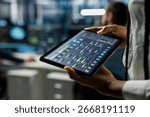 Close up of data center developer running simulations on tablet for AI forecasting, tracking performance. Server hub IT expert using device, integrating artificial intelligence APIs into software