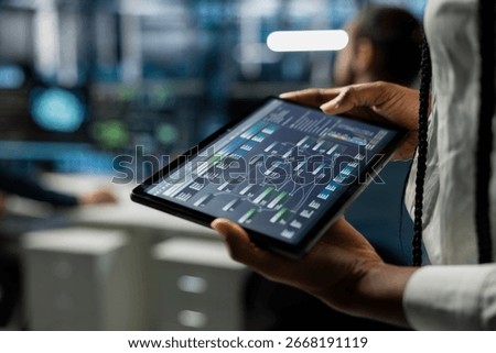 Close up of data center developer running simulations on tablet for AI forecasting, tracking performance. Server hub IT expert using device, integrating artificial intelligence APIs into software
