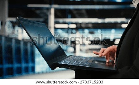 Close up of data center technician using AI LLM assistant on laptop to troubleshoot issues. Server hub specialist using artificial intelligence model on notebook to analyze system logs