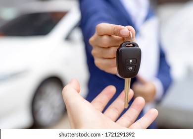 Close up of dealer giving key to new owner and shaking hands in auto show.auto business, car sale, deal,concept - Shutterstock ID 1721291392
