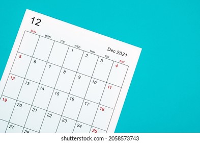 Close up December 2021 calendar sheet on green background.