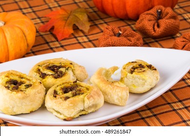 Close Up Of Decorated Table And Plate With Fresh Baked Beef Pumpkin Pinwheels.