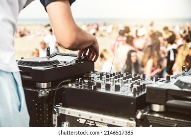 Close up of deejay playing electronic music at summer beach party - Music festival and club party event concept 