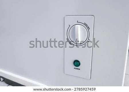 Close up of deep chest freezer temperature control switch adjustment panel with cooling freezing mode