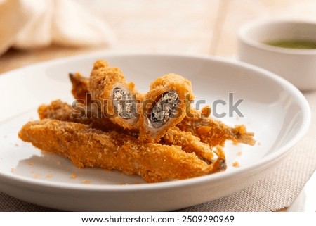 Close up Deep fried Capelin Fish (Shishamo),Thai fried battered egg fish in white plate.Selective focus.