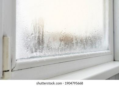 Close up of a defective plastic window with condensation and freezing inside. Poor ventilation, high humidity and temperature differences.