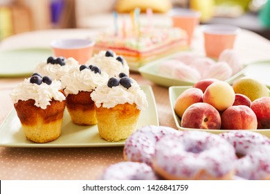 Close Up Of Delicious Blueberry Cupcakes On Table Set For Kids Birthday Party, Copy Space