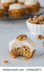 A Close Up Of A Delicious Carrot Cake Muffin With A Bite Out.