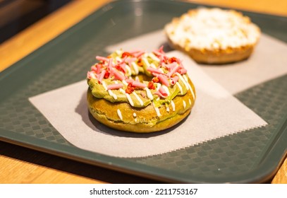 Close Up Of A Delicious Green Tea Donut (doughnut) With Green Tea And Strawberry Chocolates Topping, Osaka, Japan