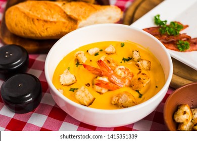 Close Up Of Delicious, Tasty Cream Soup With King Prawns And Croutons. Beautiful Serving Dishes. Salt, Pepper, Spices, Bacon, Fresh Baguette. View From Above.