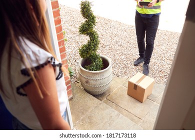 Close Up Of Delivery Driver Putting Package On Doorstep Outside House