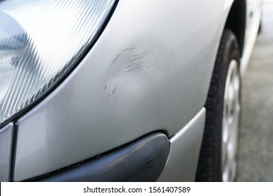 Close Up Of Dent And Scratches On Side Of Old Silver Gray Car. Damage From Crash Accident, Parking Lot Or Traffic.