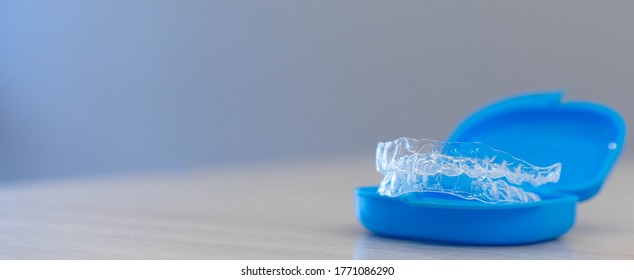 close up dental aligner retainer (invisible) on dentist's table office background for teeth treatment course concept