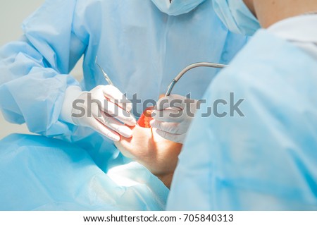 Close up dental surgery process - Implantation. Dentist surgeon with assistant in modern clinic. Stomatology and health care concept. selective focus. Space for text.