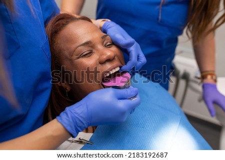 Close up of a dentist's hands placing an impression tray at the dental clinic
