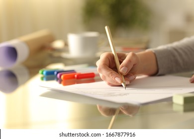 Close up of designer woman hands drawing sketch with pencil on a desk at home