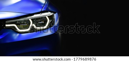 Close up detail blue modern car headlights with led technology on black background free space on right side for text.