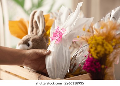 Close up detail of brazilian woman holding white easter egg in wooden basket at home - Powered by Shutterstock