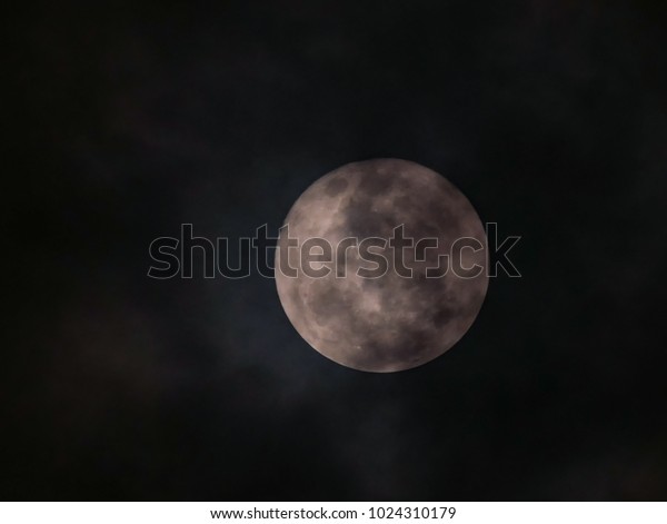 close up the detail of\
full moon with cloudy sky on black background , zoom image with\
telephoto lens