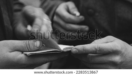 Close up detail german soldiers World War II s uniform. German military decoration on the uniform. Soldiers holding checking in their hands and flip through paper documents id passport. Black And
