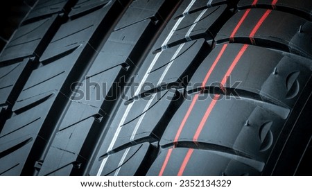 CLOSE UP DETAIL OF GROOVES TIRE TREAD FOR CAR GRIP ON THE ROAD FOR SAFETY. VEHICLE MAINTENANCE IN WORKSHOPS.