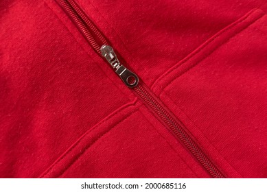 Close Detail Of Kids Red Hoodie Sweatshirt With Zip Fastener And Pocket.