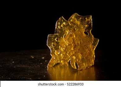 Close up detail of marijuana oil concentrate aka shatter isolated on black background