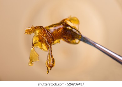 Close Up Detail Of Marijuana Oil Concentrate Aka Shatter Dab On Light Background