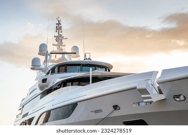 Close up detail of a modern charter or private superyacht, with a dramatic sky in the background
