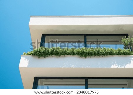 Close up detail of modern residential apartment building exterior with green plants on balcony. Modern sustainable architecture. Minimal abstract background
