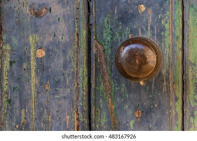 Close Up Detail Of Old Blue Weathered Door With Copper Doorknob