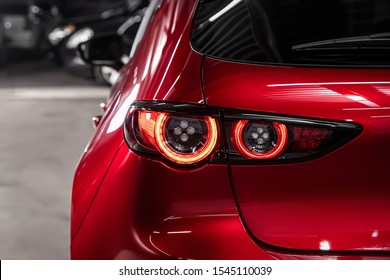  Close up detail on one of the LED red taillight modern red crossover car. Exterior detail automobile.