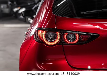  Close up detail on one of the LED red taillight modern red crossover car. Exterior detail automobile.
