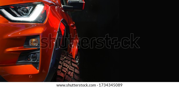 Close up detail on one of the LED headlights\
red Pickup Truck on black\
background
