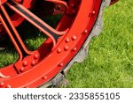 close up detail of a red and black wheel of a traction engine or steam-powered tractor