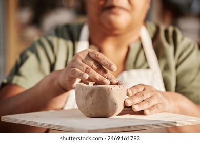 Close up detail shot of senior woman carefully shaping clay piece enjoying pottery class in sunlight copy space - Powered by Shutterstock