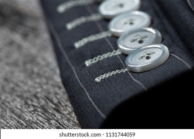 Close Up Detail Of Sleeve  Buttons And Stitching For Custom Made Jacket On Old Wooden Table, Professional Tailor Concept.Bespoke Jacket.
Pay Attention In Every Details.