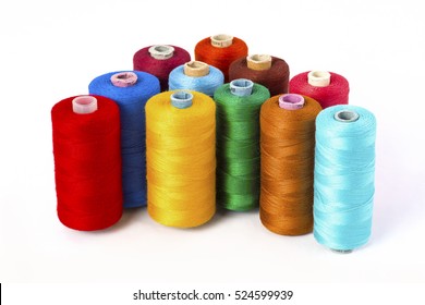 Close up detail still life of colorful red yellow green blue brown spools of thread isolated on white background copy space - concept fashion DIY clothing sewing handicraft design handmade tradition
