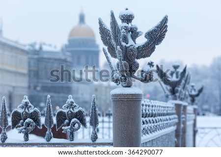 Close up details fence decorations with the Russian imperial double-headed eagle symbol covered with snow on Palace Square, St. Petersburg, Russia