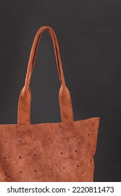 Close Up Details Of Orange Women's Genuine Thick Leather Shopper Bag Isolated Over Black Background. Minimalist Sustainable Fashion Accessories. Luxury Stylish Large Female Bag For Shopping Everyday
