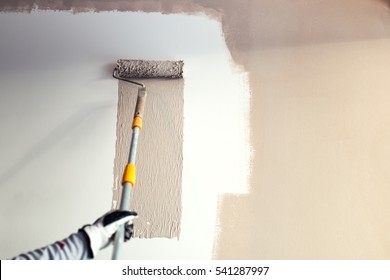 close up details of painting walls, industrial worker using roller and other tools for painting walls