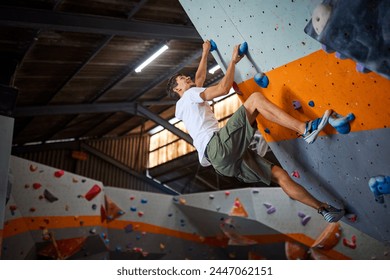 Close Up Of Determined Man Tackling Climbing Wall At Indoor Activity Centre - Powered by Shutterstock